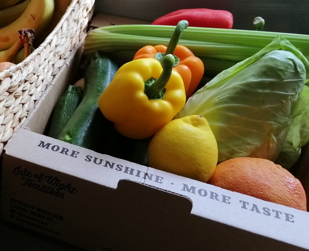 Bright assortment of fresh fruits and vegetables in box.